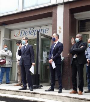 Le personnel et les dirigeants du CFA Delépine sur les marches de l'établissement, lisant leur lettre aux apprentis.